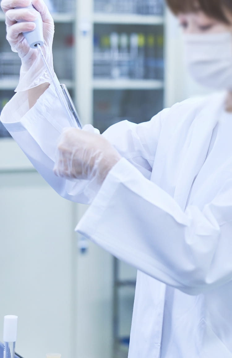 スポイトで薬品を確認している女性